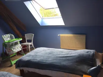 Un ou plusieurs lits dans un hébergement de l'établissement Gîte spacieux avec cheminée et salle de jeux - FR-1-491-442