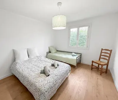 Un ou plusieurs lits dans un hébergement de l'établissement Maison lumineuse, jardin et Wi-Fi gratuit