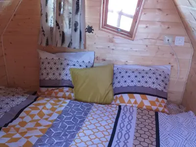 Un ou plusieurs lits dans un hébergement de l'établissement Cabane avec jacuzzi privatif et accès à ferme pédagogique - FR-1-410-459