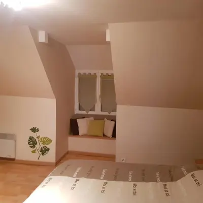 Un ou plusieurs lits dans un hébergement de l'établissement appartement a l'étage d'une maison avec entrée commune comprenant une chambre avec un grand lit , une d'enfant et un clic-clac dans la piece de vie