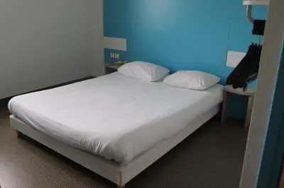 Un ou plusieurs lits dans un hébergement de l'établissement First Inn Hotel Blois