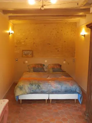 Un ou plusieurs lits dans un hébergement de l'établissement LA PETITE LUCETTE, maison avec sa cour et son troglo