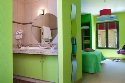 Un ou plusieurs lits dans un hébergement de l'établissement Logis hôtel Ô en Couleur