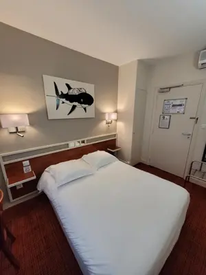 Un ou plusieurs lits dans un hébergement de l'établissement Logis Hôtel Restaurant LE MONARQUE