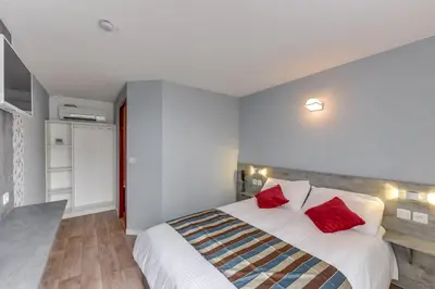 Un ou plusieurs lits dans un hébergement de l'établissement Confort Hôtel Thouars