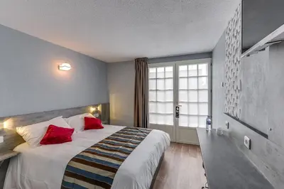 Un ou plusieurs lits dans un hébergement de l'établissement Confort Hôtel Thouars