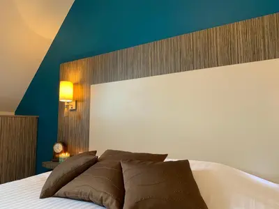 Un ou plusieurs lits dans un hébergement de l'établissement Logis Hotel La Croix Blanche Fontevraud