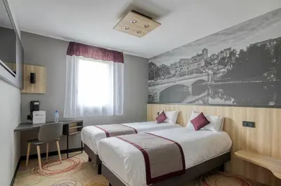 Un ou plusieurs lits dans un hébergement de l'établissement Brit Hotel Le Cottage Le Mans Sud