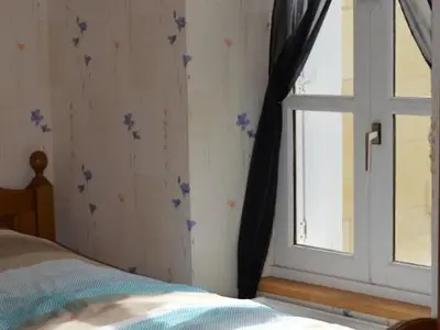 Un ou plusieurs lits dans un hébergement de l'établissement Charmante maison avec jardin privé, cheminée et WIFI - FR-1-381-67