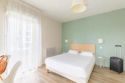 Un ou plusieurs lits dans un hébergement de l'établissement Appart’City Confort Tours