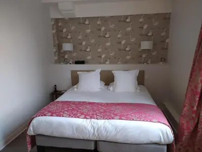 Un ou plusieurs lits dans un hébergement de l'établissement Logis Hotel Restaurant Le Cheval Blanc