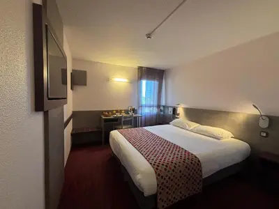 Un ou plusieurs lits dans un hébergement de l'établissement Brit Hotel Les Evens