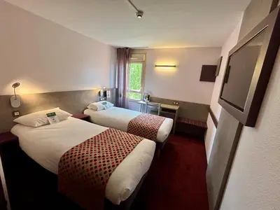 Un ou plusieurs lits dans un hébergement de l'établissement Brit Hotel Les Evens