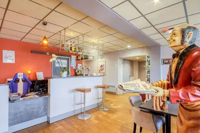 Télévision ou salle de divertissement dans l'établissement Brit Hotel Les Evens