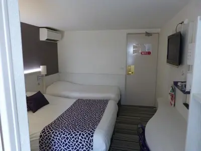 Un ou plusieurs lits dans un hébergement de l'établissement Logis Hôtel Alizéa Le Mans Nord
