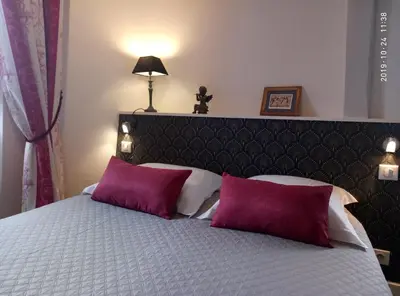 Un ou plusieurs lits dans un hébergement de l'établissement Petite Maison Romantique au calme, Cœur Historique, vue Ville et Jardin